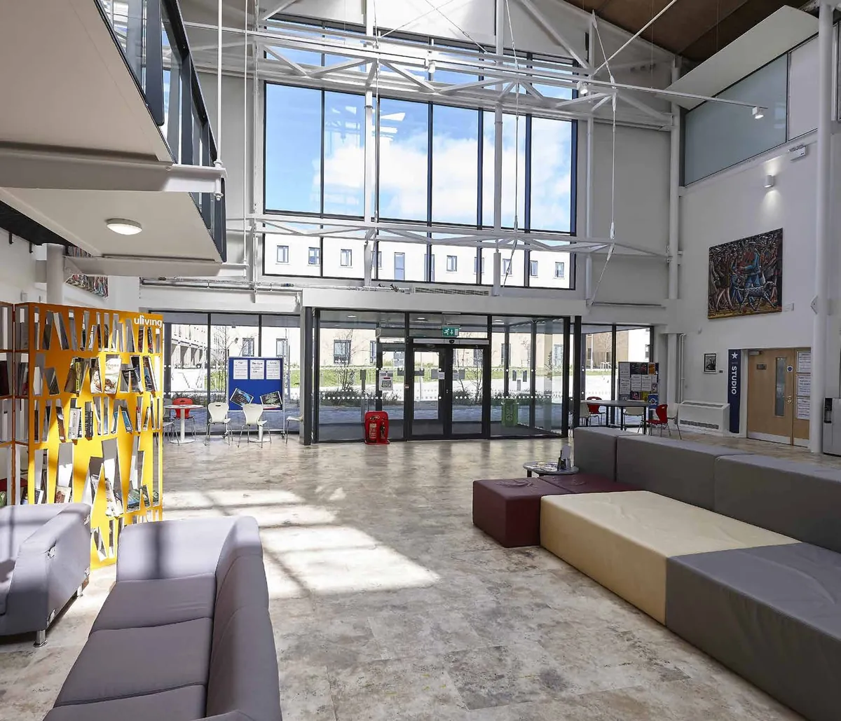 AluK GT55 TB commercial double entrance doors and glazed screen in a bright school atrium