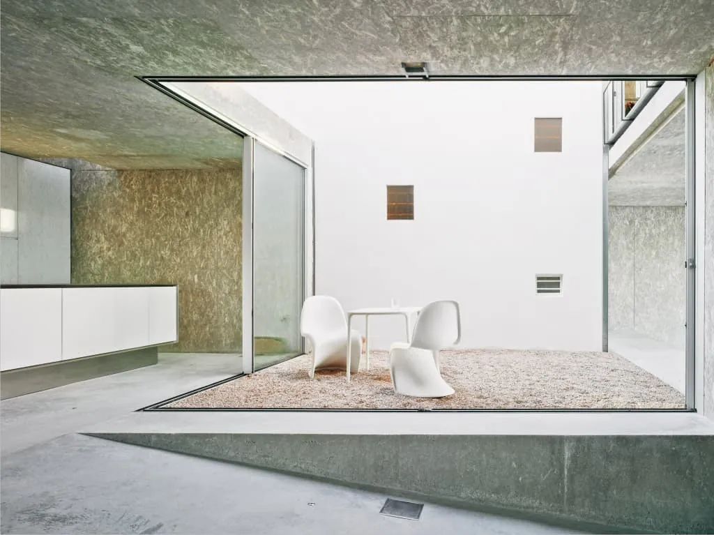 Cor Vision sliding doors meeting at a corner with no post, opening a room fully onto a courtyard