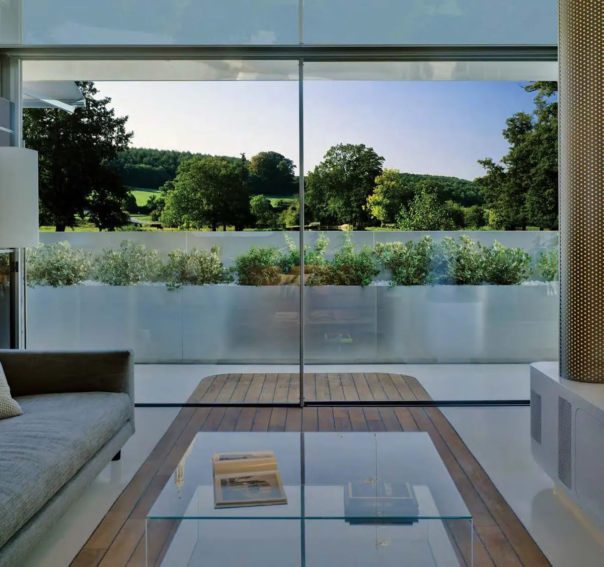 View out through Cor Vision sliding doors from a living room to a terrace and countryside, showing the slim interlock
