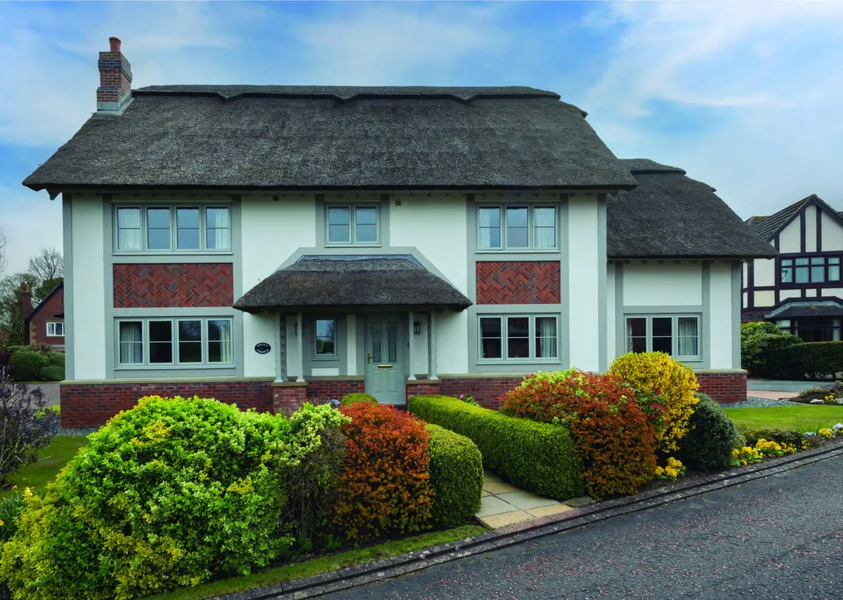 The same Mock Tudor house after renovation with Painswick Timberlook windows and matching beams